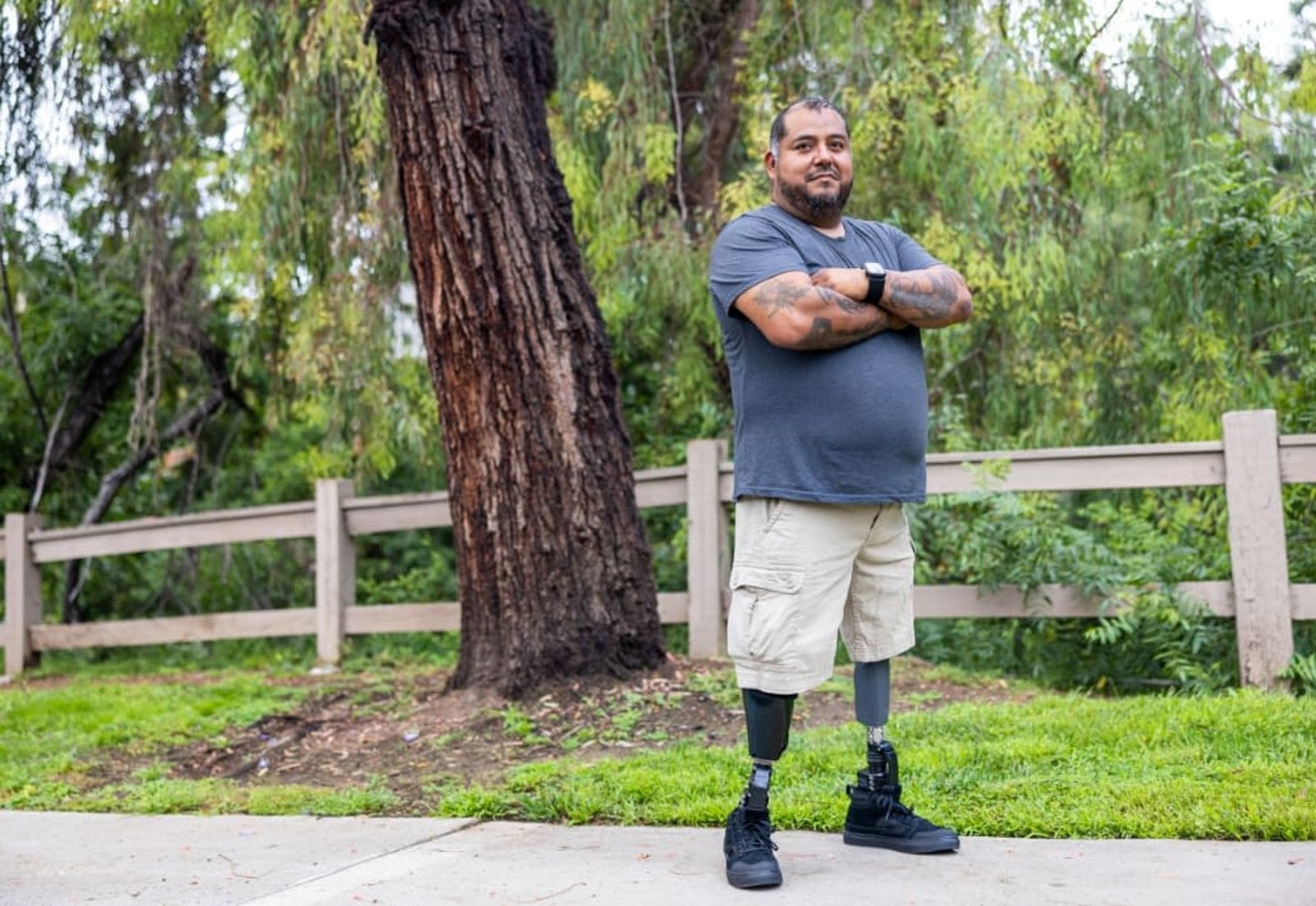 Disabled U.S. Army combat veteran with prosthetic legs standing confidently outdoors