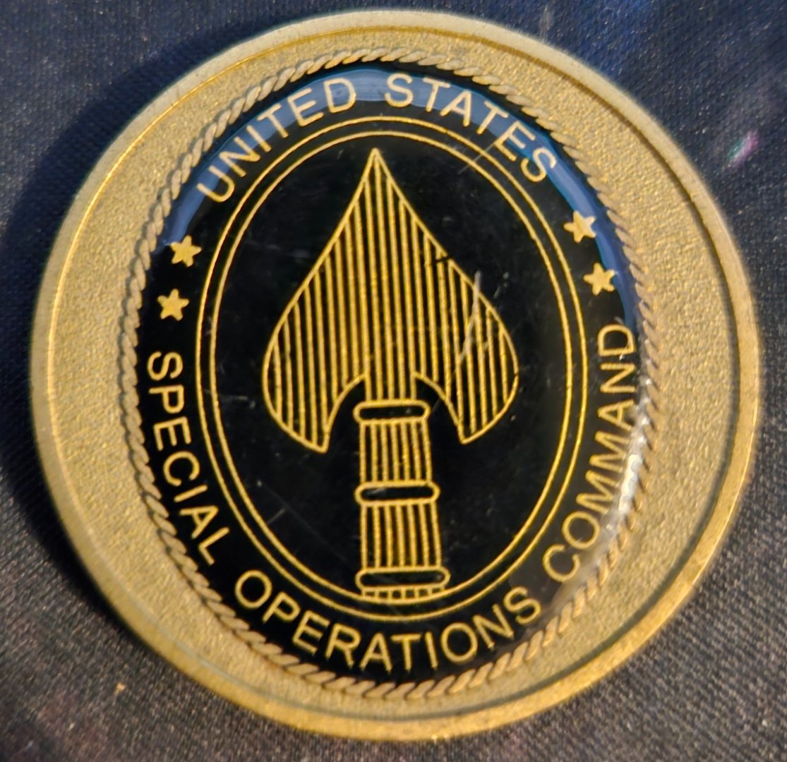 United States Special Operations Command challenge coin, front face with the SOCOM spear emblem
